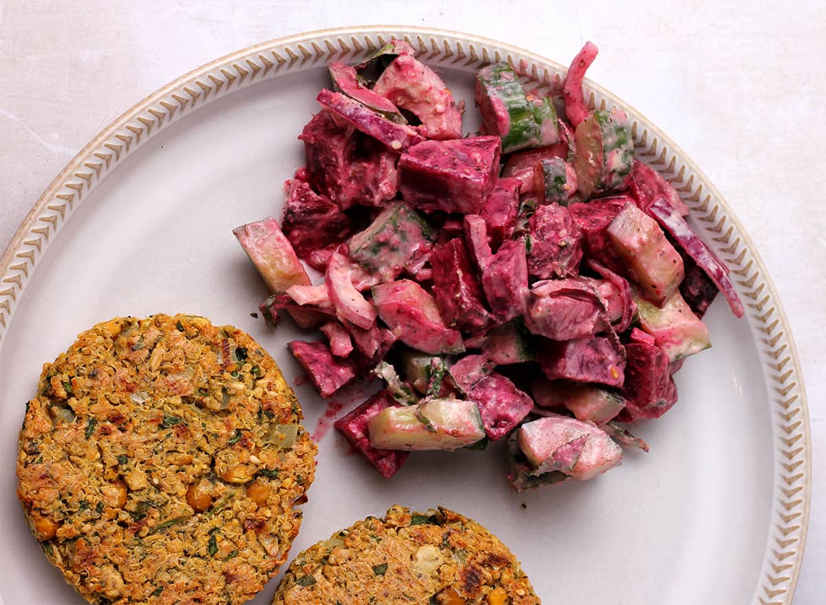Beet and cucumber salad on a plate with chickpea patties.