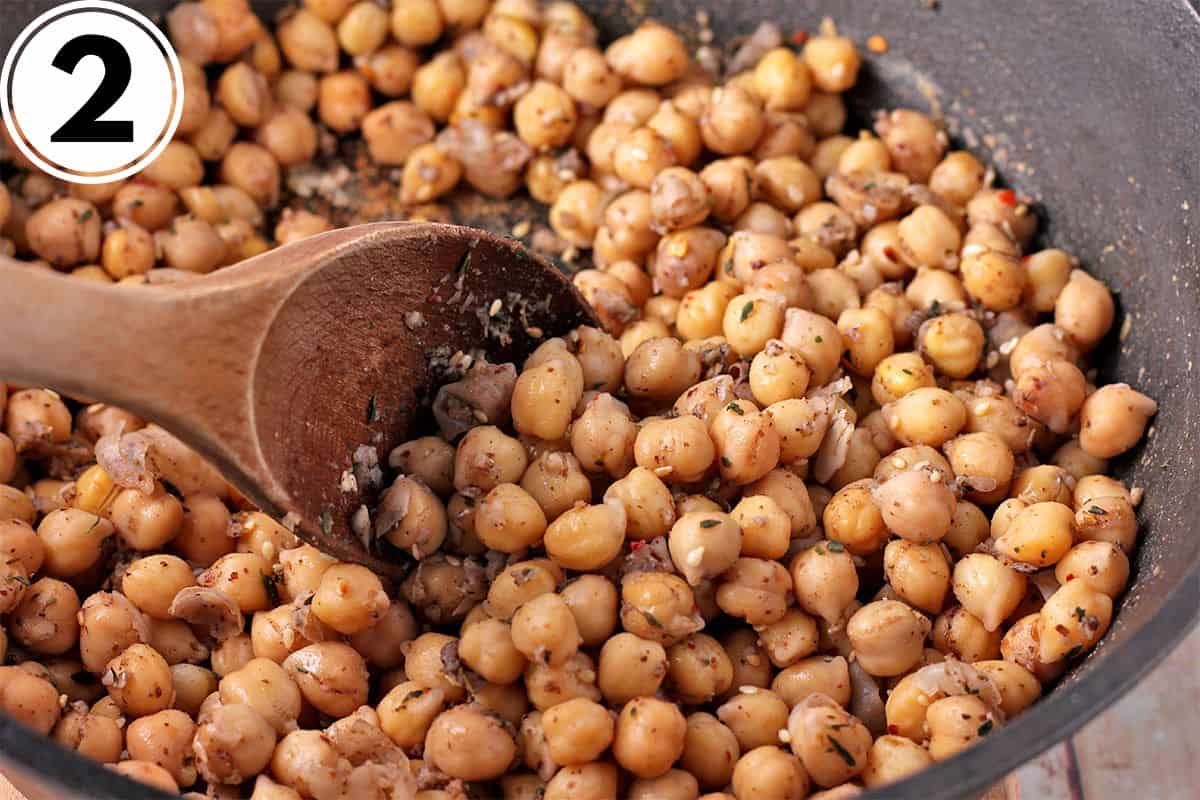 Chickpeas and za'atar are stirred in a pot.