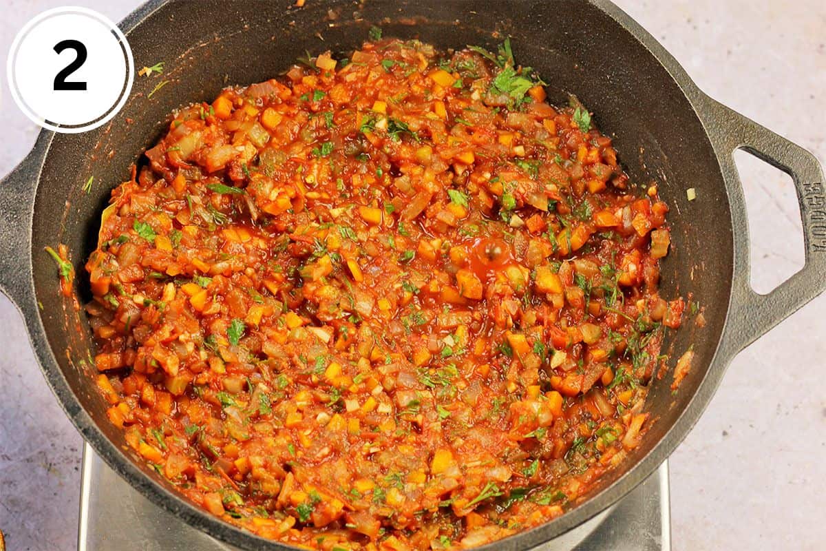 Cooked vegetables in tomato sauce with fresh dill and parsley.