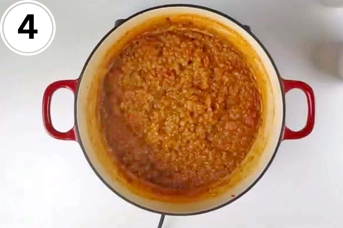 Red lentils are cooked in a pot.