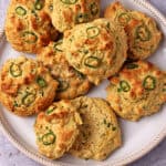 Jalapeno vegan biscuits on a plate with a cut biscuit in front.