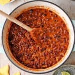 Chipotle black beans in a pot with lime wedges in a small dish.