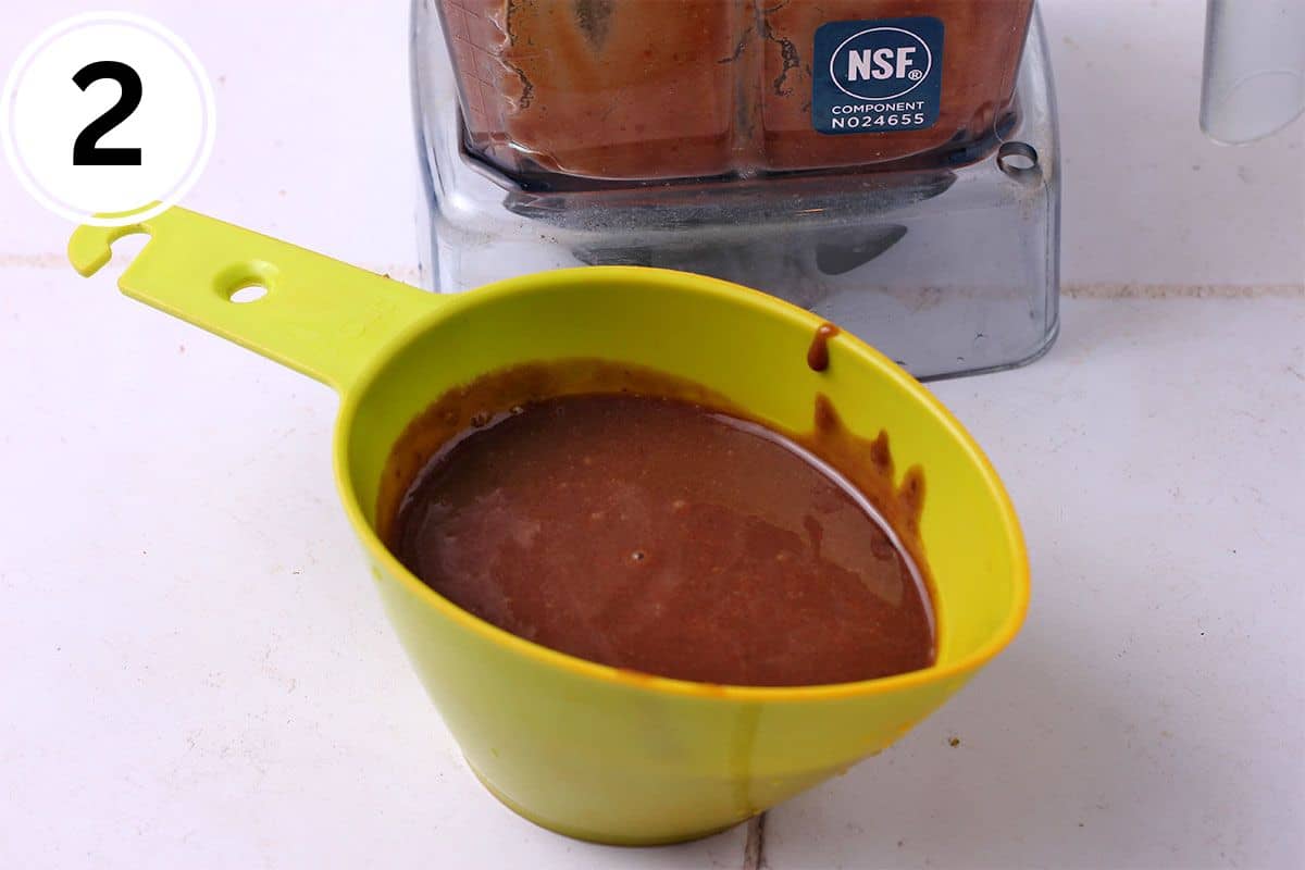 Pomegranate vinaigrette dressing in a green measuring cup.
