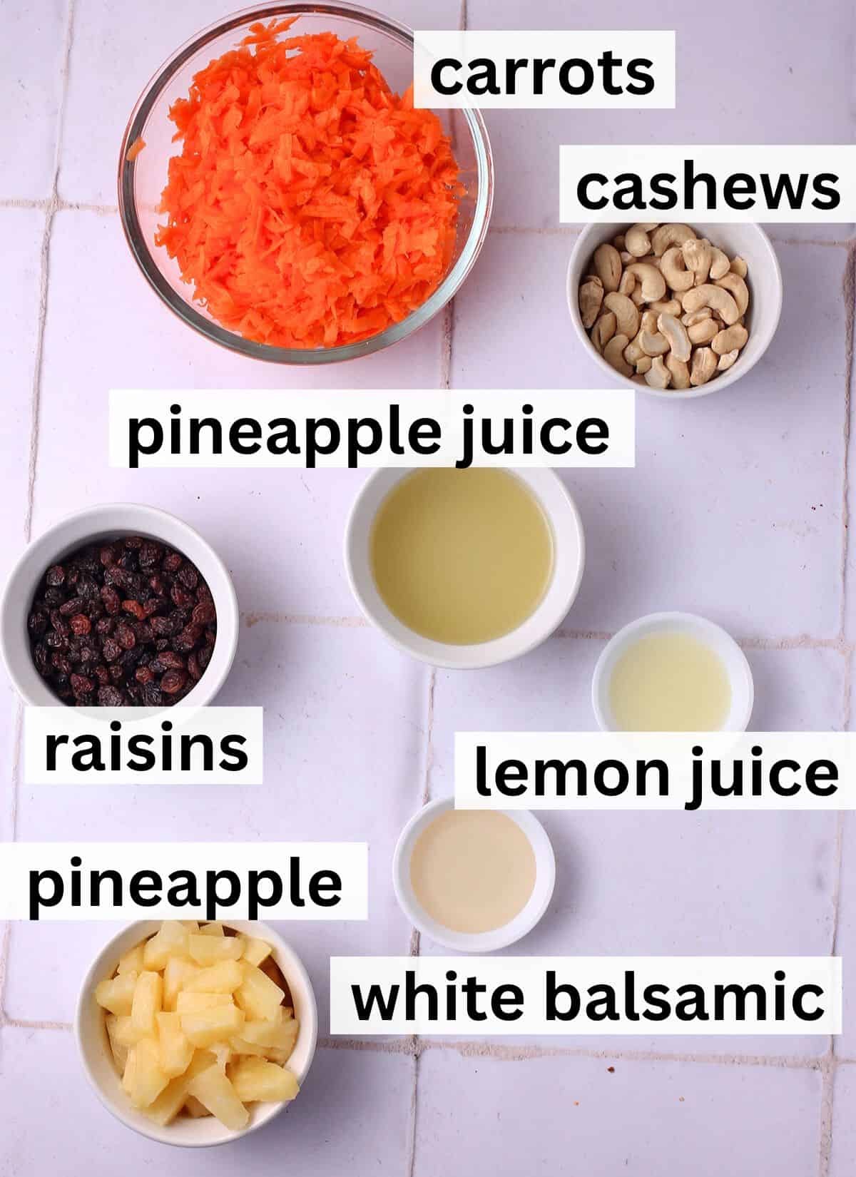 The ingredients for carrot raisin salad with pineapple with labels next to each ingredients.