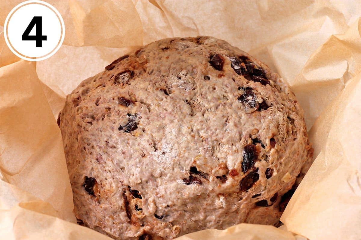 Bread dough ball in parchment paper in a bowl.