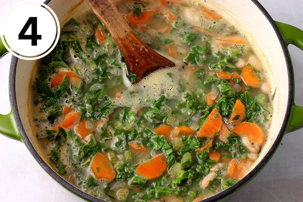 Kale is stirred into white bean soup with carrots, celery, and onions.