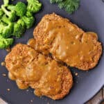 Breaded chickpea cutlets with mustard sauce and broccoli on a plate.