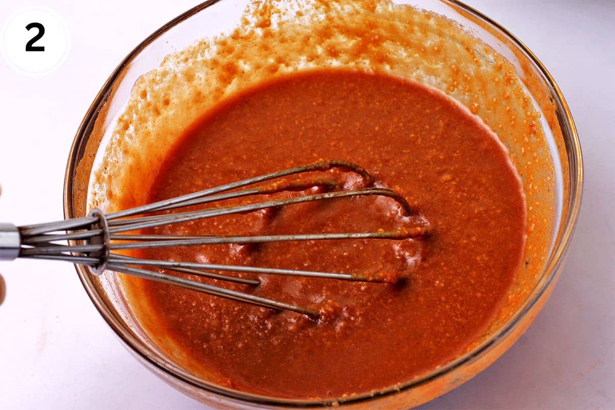Spicy peanut sauce is whisked in a bowl.