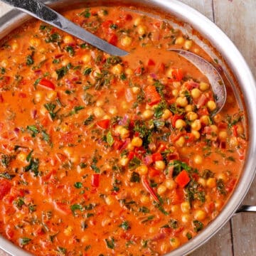 A pan of chickpeas and kale in harissa sauce.