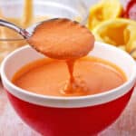 A spoonful of sriracha tahini dressing over a bowl.