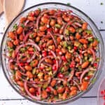 Overhead of borlotti bean salad with pomegranate, walnuts, celery, and red onions.