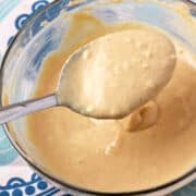 Bowl of maple tahini dressing with dressing in a spoon.