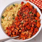 Moroccan chickpea stew in a white bowl with a spoon.