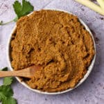 A bowl of massaman curry paste in a bowl with a small wooden spoon.