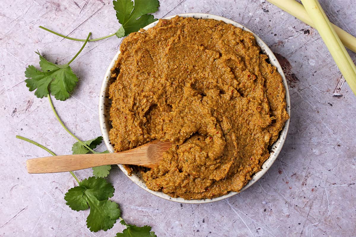A bowl of massaman curry paste with a small wooden spoon in the bowl.