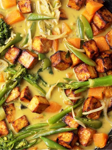 Vegan Thai green curry with tofu, broccoli, snap, peas, sweet potato, and bean sprouts.