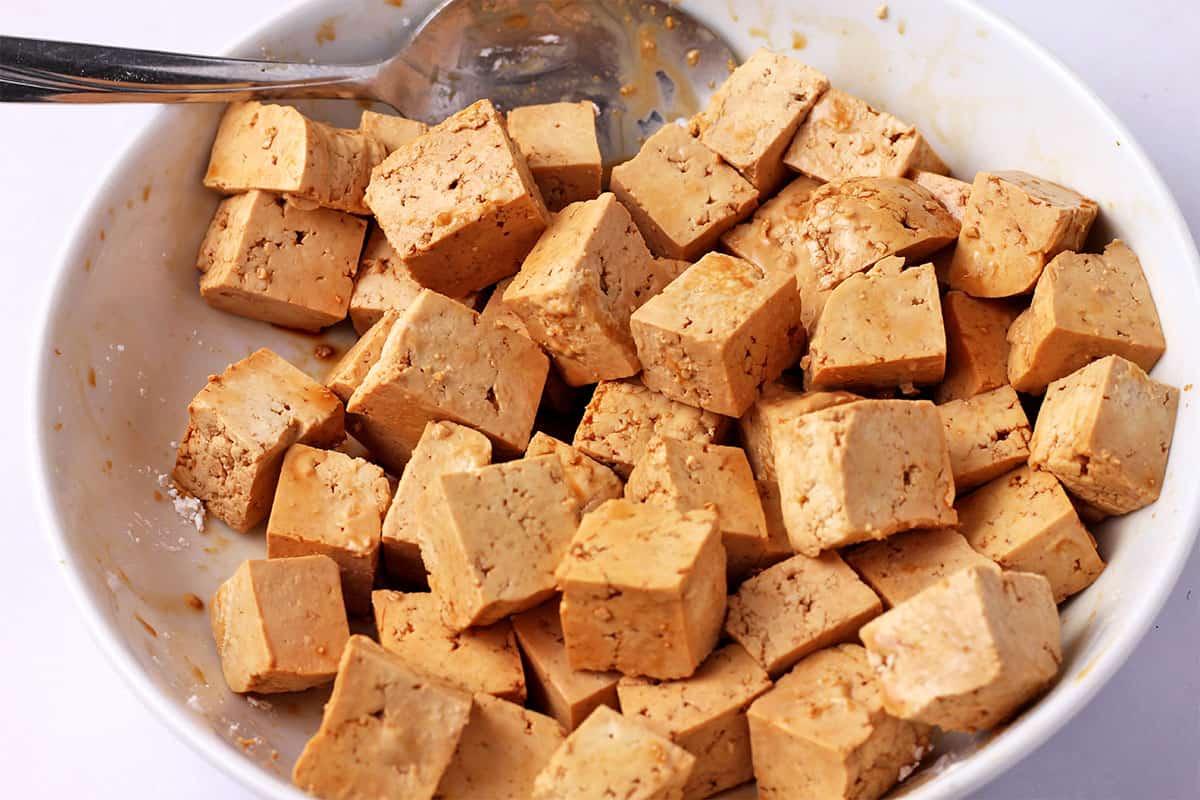 Tofu cubes in a bowl with soy sauce and cornstarch.