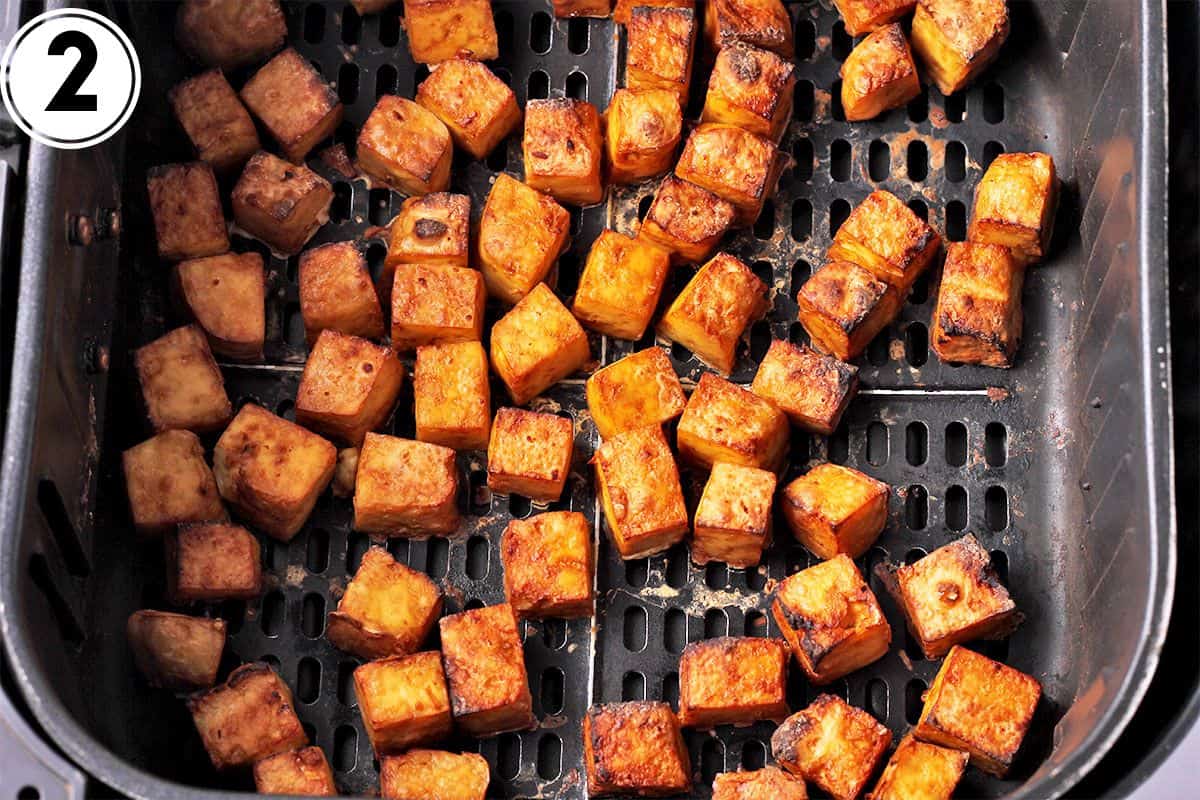 Air fried crispy tofu in air fryer basket.