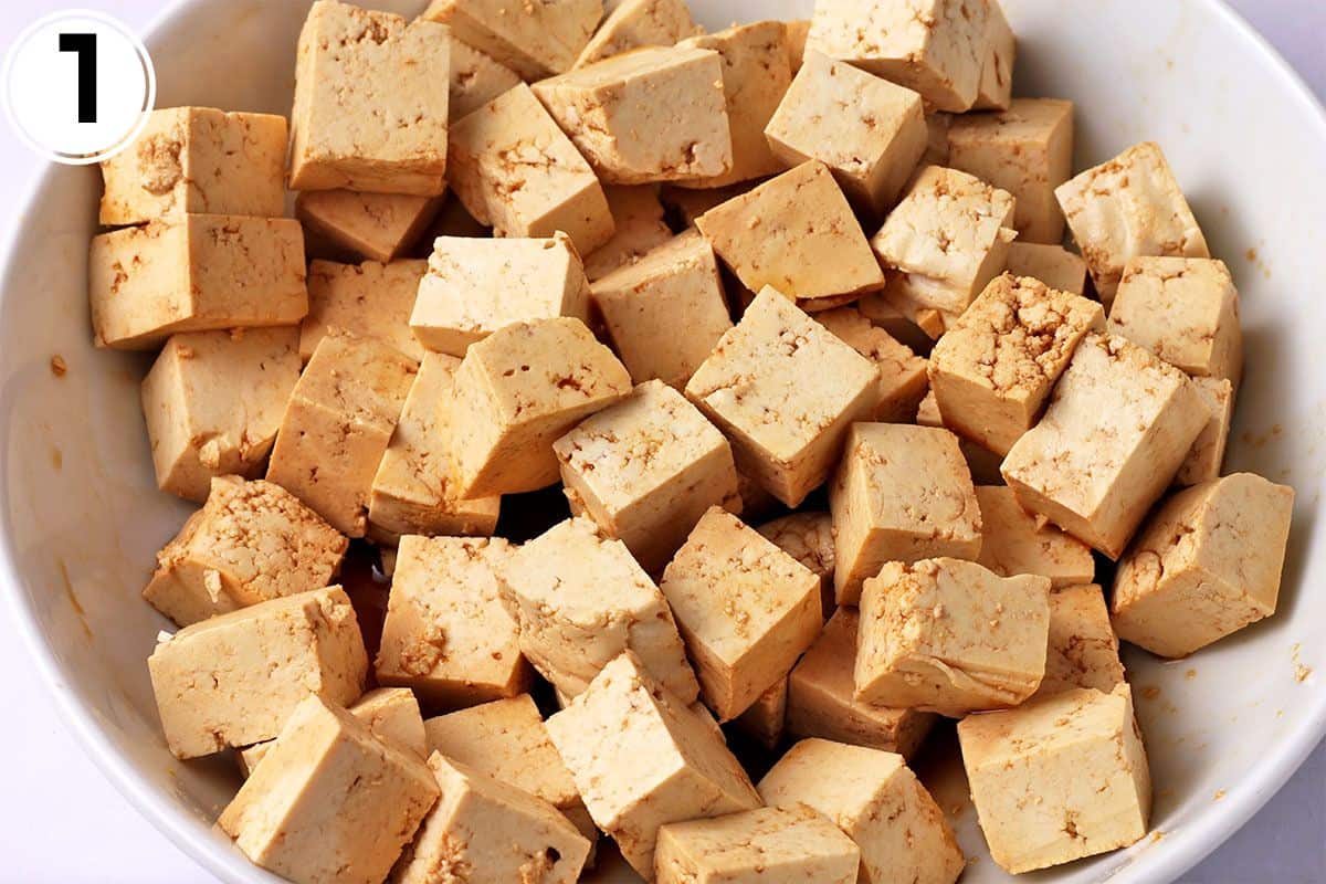 Tofu cubes with soy sauce and cornstarch in a white bowl.