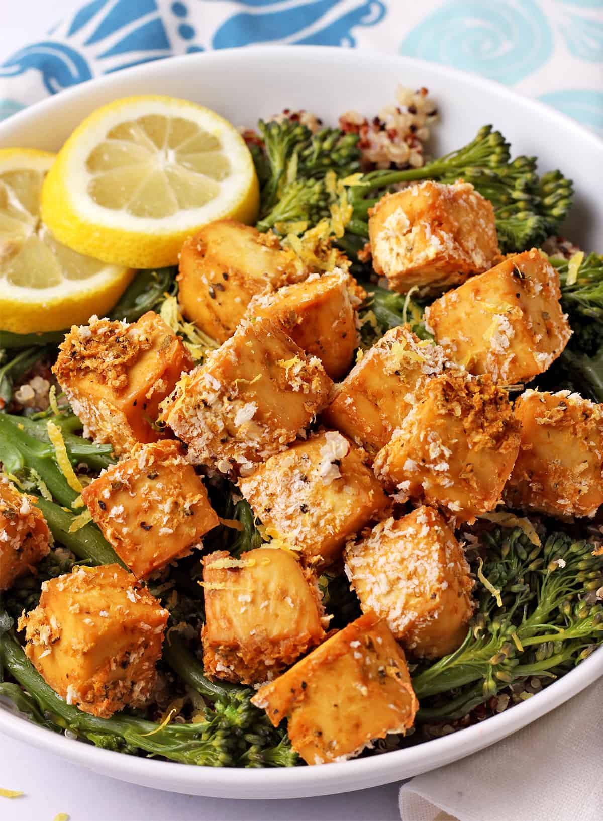 A bowl with rice and steamed broccoli is topped with lemon panko tofu cubes.